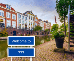 Znak stojący przed holenderskim kanałem z napisem „Witamy w ???”.